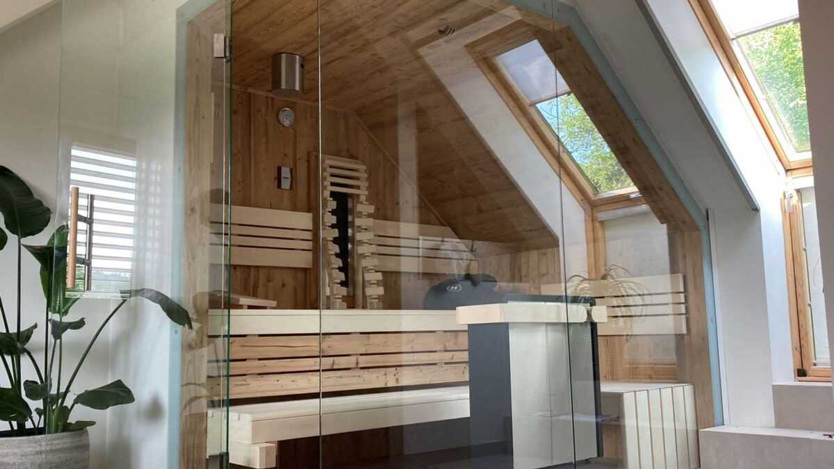 Moderne Innensauna mit Glas unter einer Dachschräge
