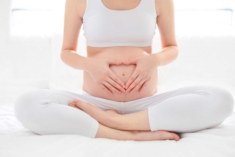 Schwangere Frau hält Bauch